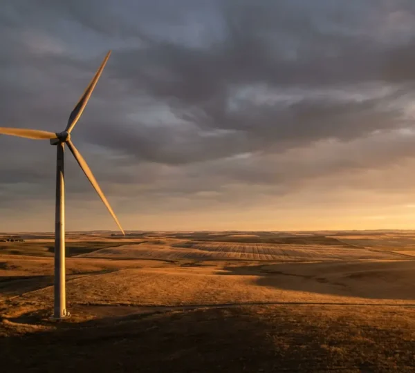 Éolienne domestique installée dans un paysage rural venteux avec ciel nuageux dynamique.